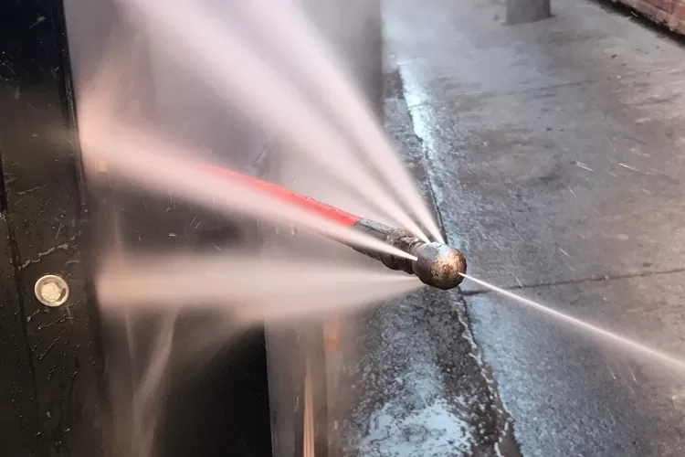Profissional realizando hidrojateamento de alta pressão